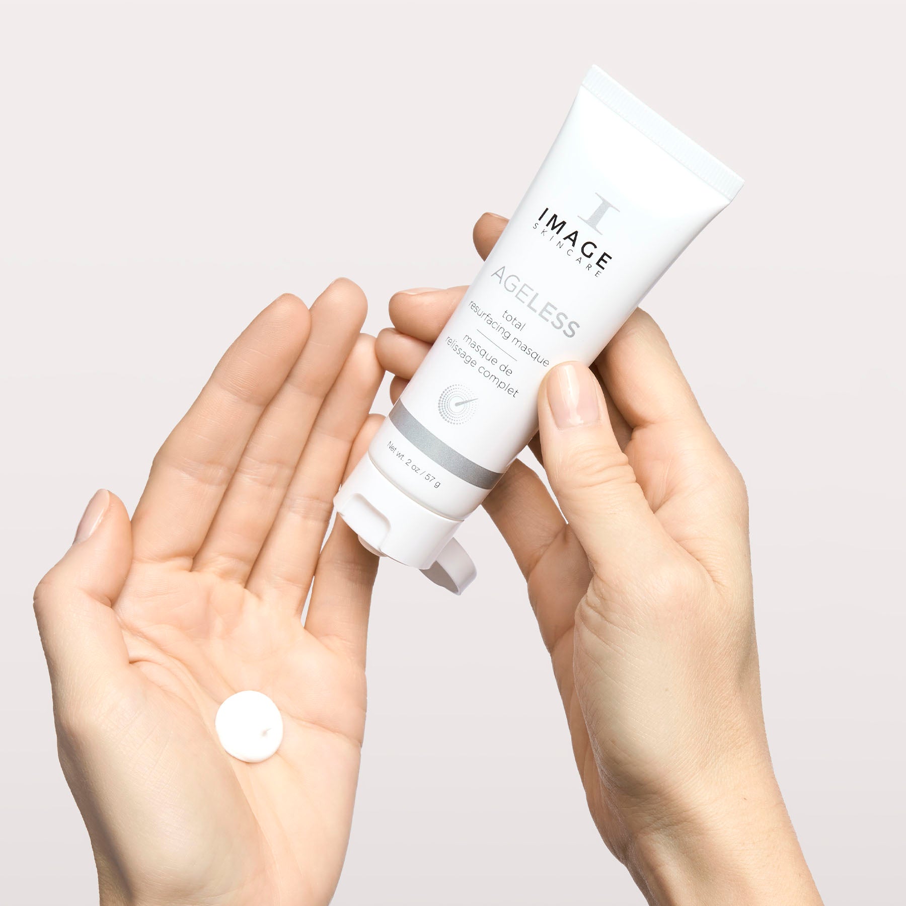 model hands holding bottle and applying product to palm