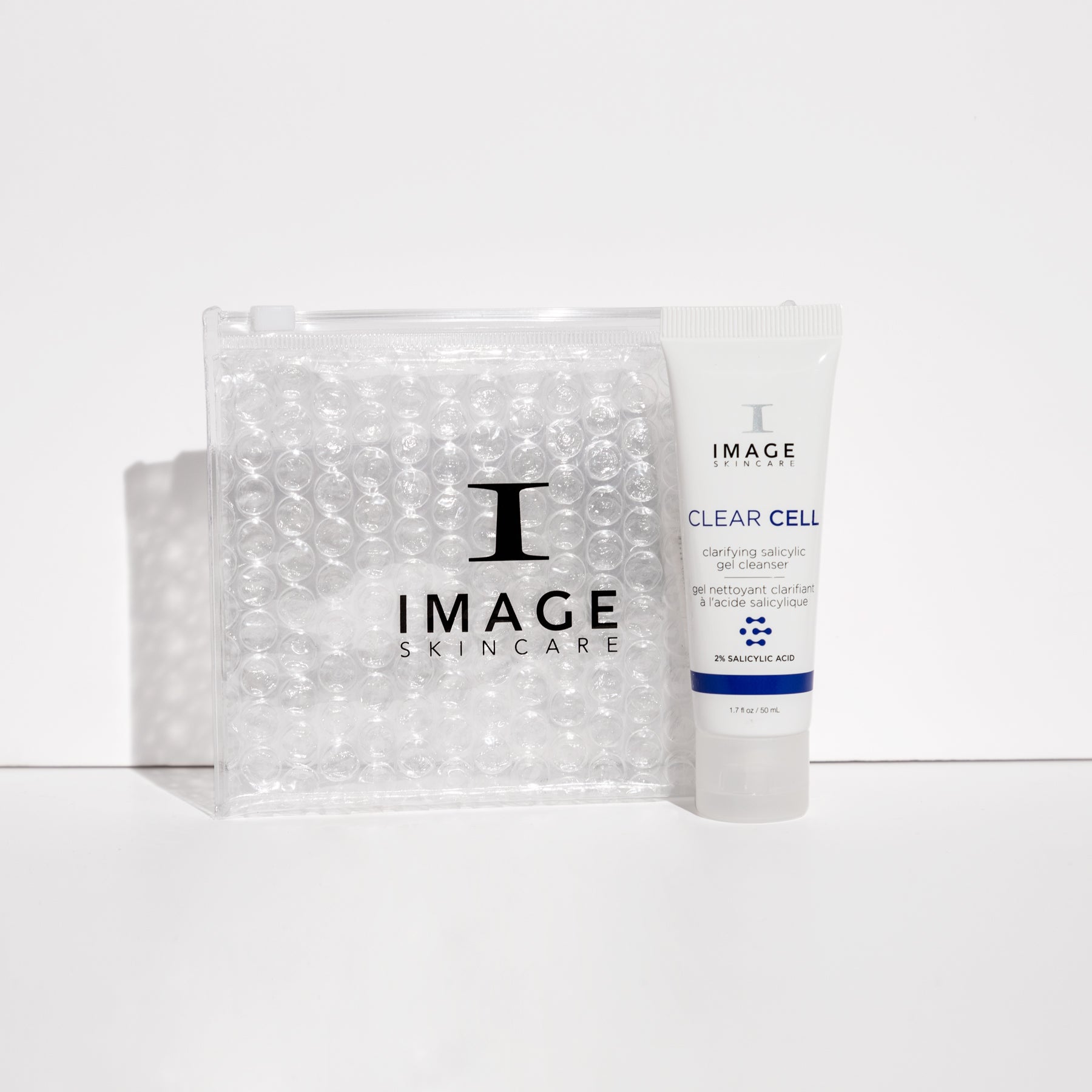 clear cell cleanser travel size tube next to clear bubble bag