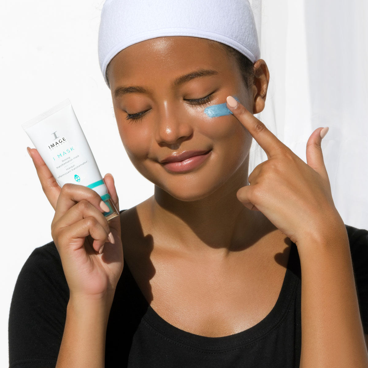 model applying mask onto cheek with finger