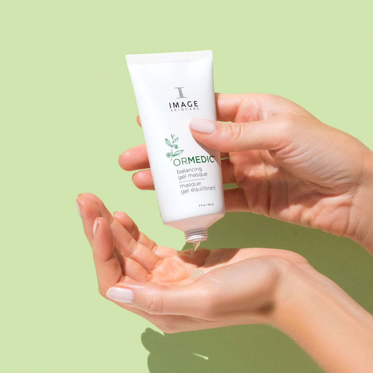 model hands squeezing tube to dispense product on palm
